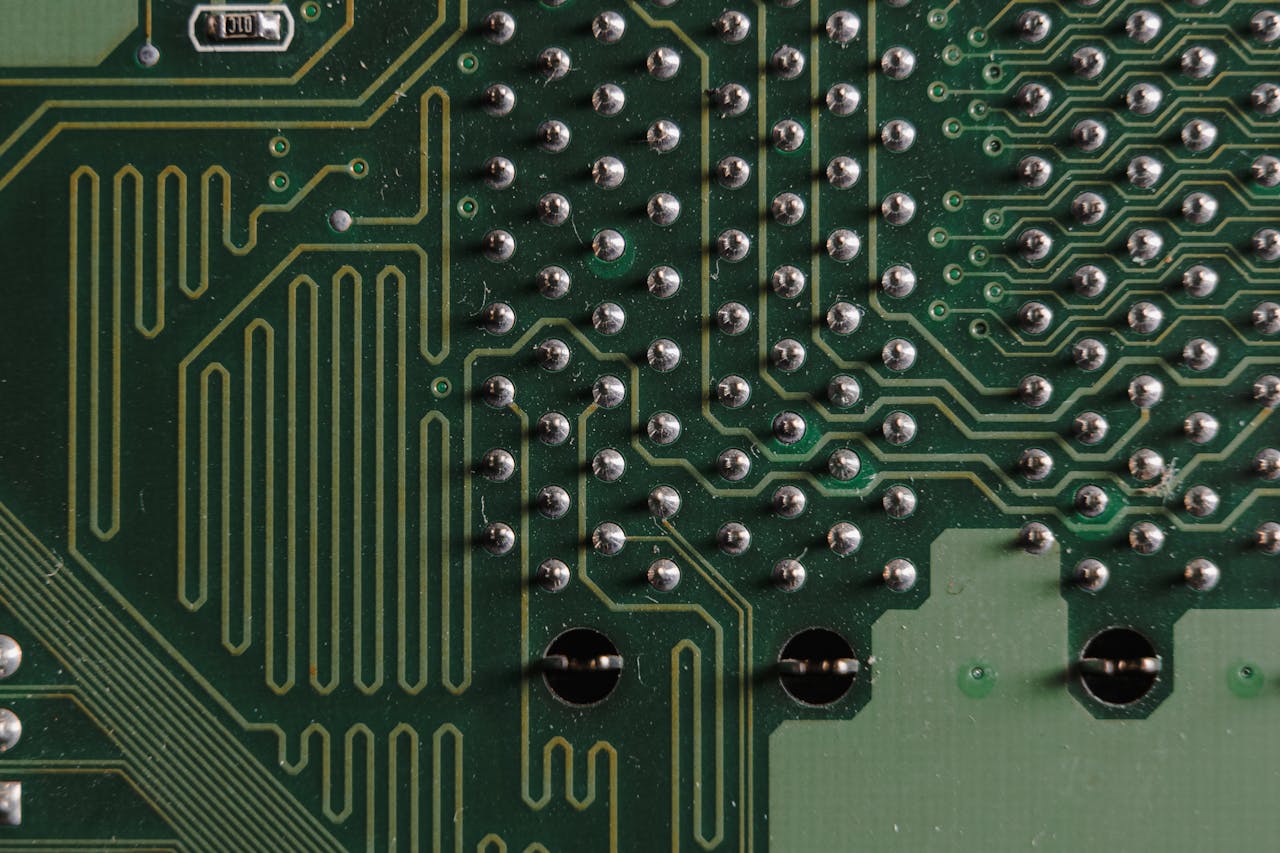 Service Detailed close-up of electronic circuit board with intricate green patterns and components.